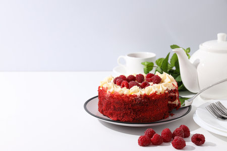 Red velvet cake, teapot, mint and berries on white background, space for textの写真素材