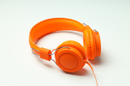 On-top, large, bright orange headphones, on a light background.の写真素材