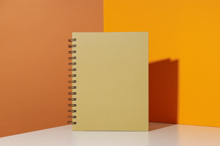 The notebook stands on a yellow background