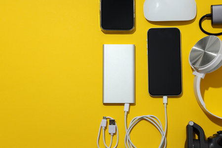 Power bank with gadgets on a yellow backgroundの写真素材
