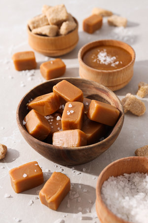 Cubes of salted caramel in a wooden bowlの写真素材
