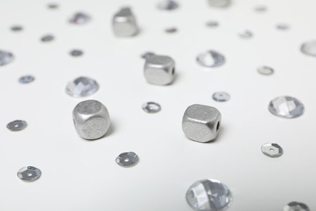 Sequins and beads of silver color on white background, close upの写真素材