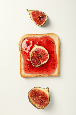 Figs and jam on piece of bread on white background, top viewの写真素材