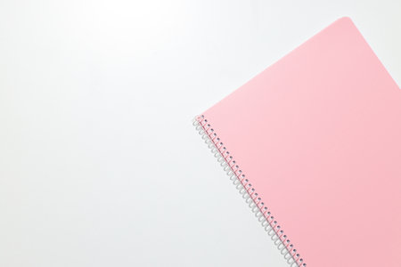 A pink notebook lies on a white backgroundの写真素材