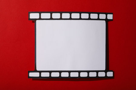 Fragment of paper film on red background, top viewの写真素材