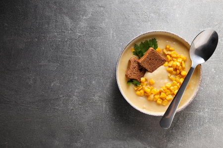 Corn soup in a plate, on a gray background.の写真素材