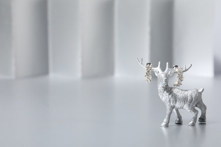 Silver deer figurine and earrings on gray background, space for textの写真素材