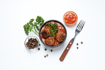 Meatballs in a bowl with spices and sauce on a light background