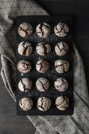 Delicious grinkle cookies on a black, stone board.