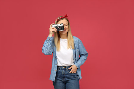Girl photographer in a photo studio, on a pink background.