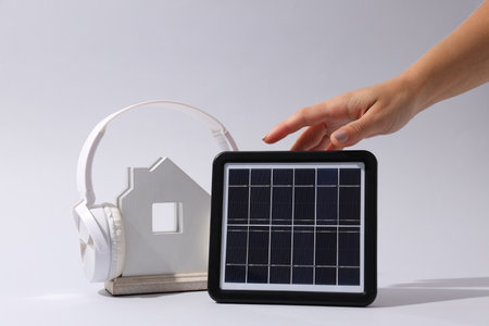 Portable solar panel with headphones and wooden house