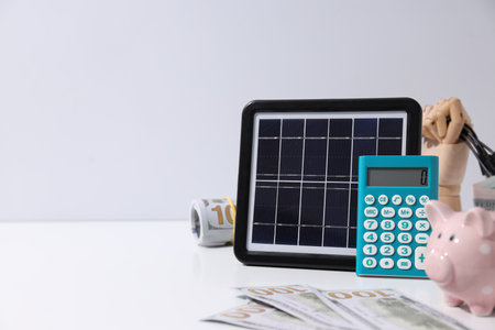 Portable solar panel with calculator and moneyの写真素材