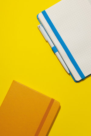 Two notebooks lie on a yellow backgroundの写真素材
