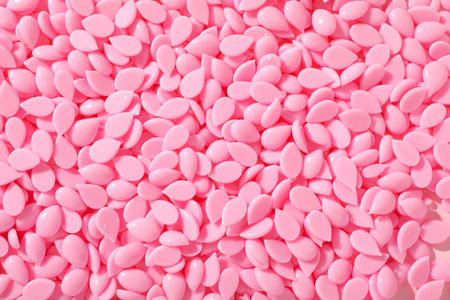 Wax granules for depilation on a pink background