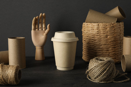 Paper materials for upcycling, wooden hand, twine and basket on gray backgroundの写真素材