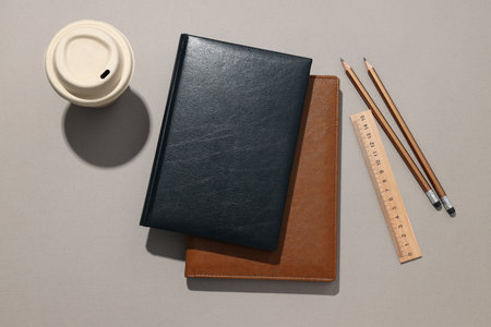Black and brown notebooks with a cup of coffeeの写真素材