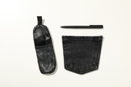 Denim pocket, handmade case and pen on white background, top view