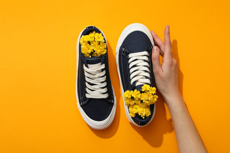 Stylish sneakers with flowers on a yellow backgroundの写真素材