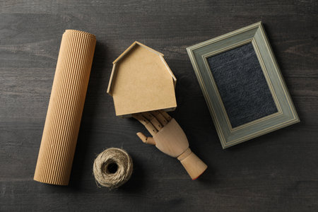 Wooden hand, photo frame, twine and handmade house on wooden background, top viewの写真素材