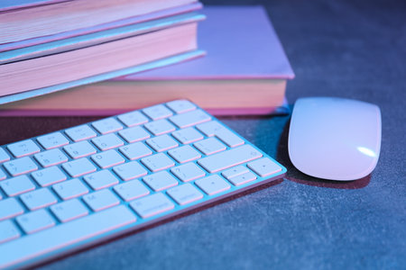 Books with a computer mouse and keyboard, on a light background.の写真素材