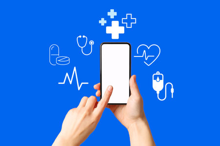 Person interacting with a smartphone displaying health-related graphics on blueの写真素材