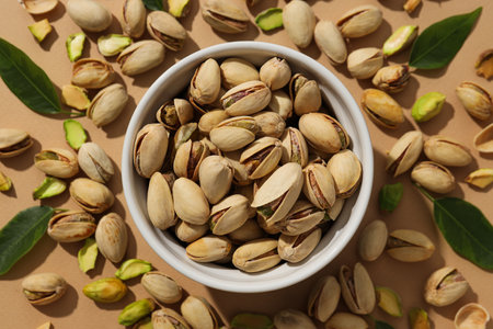 Pistachios in a plate, on a beige background.