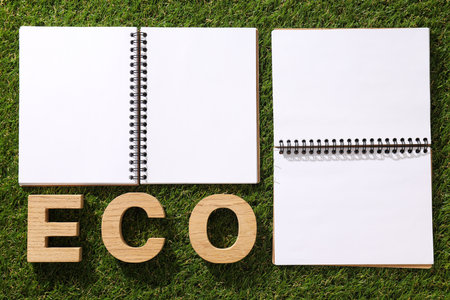 A paper notebook with a pencil on the grass.の写真素材