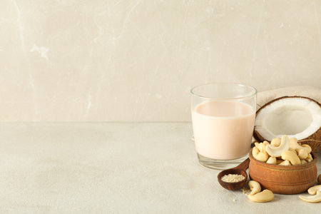 Glass with alternative milk, coconut and nuts on beige background, space for textの写真素材
