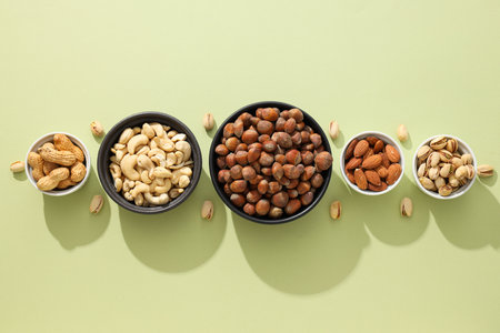 Various nuts in white and black bowlsの写真素材