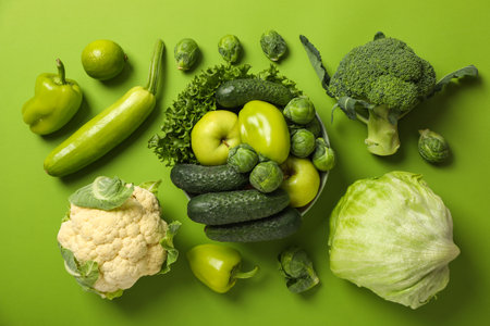 Set of protein vegetables and fruit in bowl and on green background, top viewの写真素材