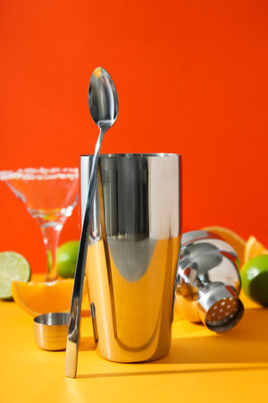 Metal shaker with fresh lime and glass