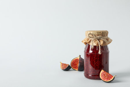 Figs and jars of jam on white background, space for textの写真素材