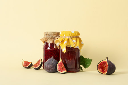 Figs and jars of jam on beige backgroundfの写真素材