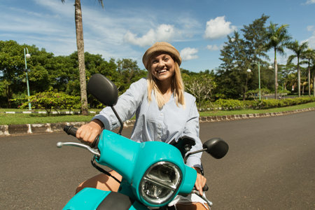 Woman enjoys a ride on her scooter through the beautiful park