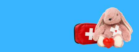 A fluffy stuffed bunny and medical kit with heart symbolの写真素材