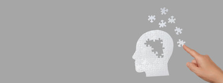 A hand interacts with a puzzle head symbolizing thoughts and ideas