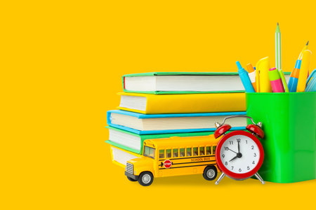 Bright school supplies: books, pencils, and a clock