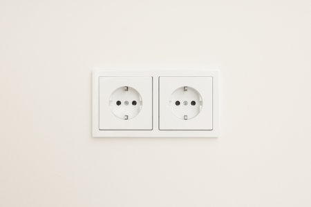 Two standard electrical outlets on a plain wall surface