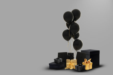 Black balloons float above elegantly wrapped gift boxesの写真素材