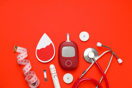 Diabetes management tools arranged on a bright orange backgroundの写真素材