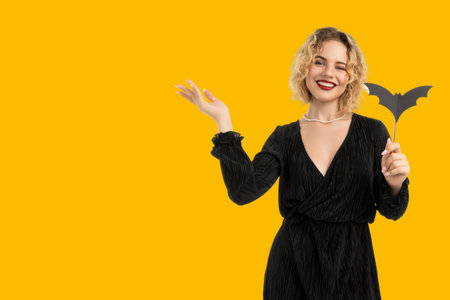 Woman in black dress joyfully celebrating Halloweenの写真素材