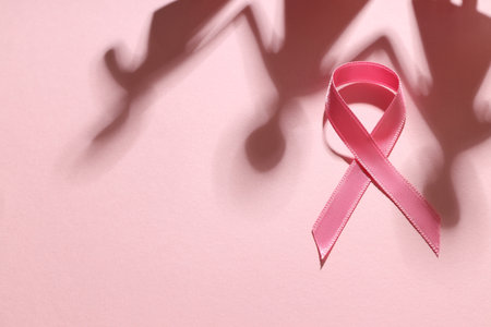 Pink awareness ribbon placed on a soft pink surfaceの写真素材