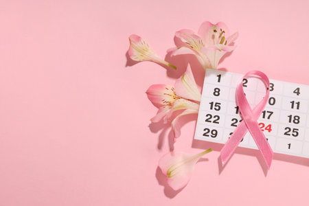 Calendar date marked with a pink ribbon and pink flowersの写真素材