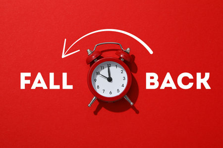 Classic red alarm clock shows time adjustment concept