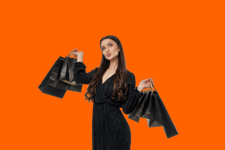 Woman holding multiple shopping bags in a vibrant settingの写真素材