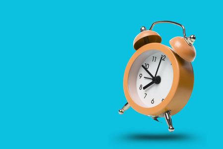Orange alarm clock displaying time on a blue background