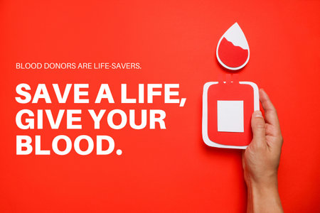 Hand holding a paper blood bag with a red backgroundの写真素材