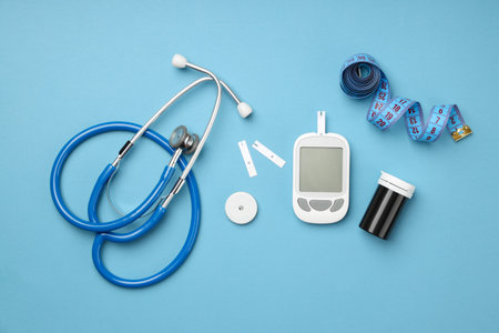 Stethoscope, glucose meter, and test strips on blueの写真素材