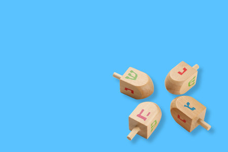 Hanukkah, four dreidels with Hebrew letters displayed on blueの写真素材