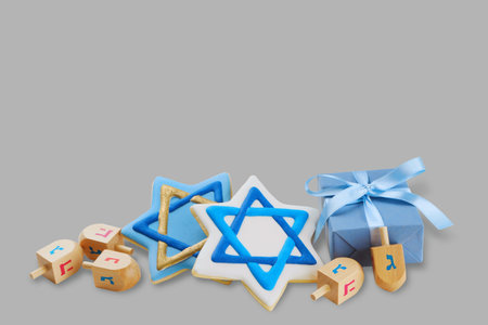 Hanukkah symbols with cookies and dreidels by a giftの写真素材
